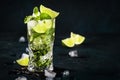 Mojito cocktail or mocktail with lime, mint, and ice in glass on blue background. Summer cold alcoholic non-alcoholic drink, Royalty Free Stock Photo