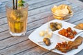 Mojito cocktail with snacks on wooden table