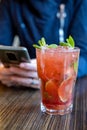 Mojito cocktail and woman with phone in cafe. Rest, chatting on the phone, paying online concept Royalty Free Stock Photo