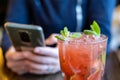 Mojito cocktail and woman with phone in cafe. Rest, chatting on the phone, paying online concept Royalty Free Stock Photo