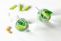 Mojito in glass jar on white wooden background and cube of ice, lime slices, cane sugar, above. Soda with fresh mint and lime Royalty Free Stock Photo