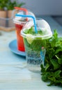 Mojito and Lemonade summer cold drink in a plastic glass with a straw. Coctail with mint, lemon, lime and ice. Serve at the bar.