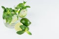 Mojito in two glasses with mint, slices lime, ice cubes, straw on soft light blue background, copy space, top view. Royalty Free Stock Photo