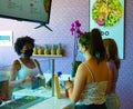 Friendly staff wearing face mask serving stylish young women wearing face masks.