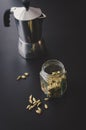 Moka pot on black background with cardamon seeds