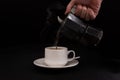 Moka coffee maker on black background and a mug