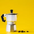 Moka coffee pot and beans roast on yellow paper background. Copy space for text Royalty Free Stock Photo