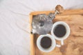 Moka coffee pot with two cup of coffe on wooden tray