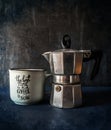 Moka pot and coffee cup dark background