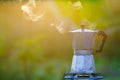 Moka pot and smoke, coffee bask on fire, In the forest at sunrise in the morning. soft focus.shallow focus effect