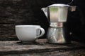 Moka pot and white coffee cup on rustic wooden background Royalty Free Stock Photo