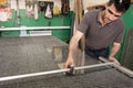 Moldova, Bender - May 18, 2019: A man of Eastern Europe measures and cuts glass for a pvc window