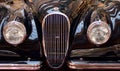 Moldova, Kishinev - May 22, 2019. Round jaguar headlight of retro car closeup black blurred background