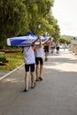 Moldova, Rybnitsa - July 2021: Athletes carry kayaks after competition on river. Spectators and fans of kayak race