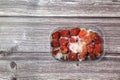 Moldy raspberries in a plastic basket on a wooden tabler. Royalty Free Stock Photo