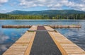 Mole, pier on the lake. Wooden bridge in forest in summer time with blue lake. Lake for fishing with pier Royalty Free Stock Photo