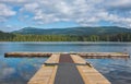 Mole, pier on the lake. Wooden bridge in forest in summer time with blue lake. Lake for fishing with pier Royalty Free Stock Photo