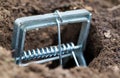 Mole trap is a trap for catching a mole in a hole in the ground. Harm from a mole in a garden plot, close-up Royalty Free Stock Photo