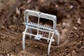 Mole trap is a trap for catching a mole in a hole in the ground. Harm from a mole in a garden plot, close-up Royalty Free Stock Photo