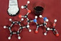 Molecule model of Aspartame a controversial artificial sweetener with associated samples. White is Hydrogen, black is Carbon, red Royalty Free Stock Photo