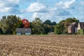 Molenbeek, Brussels Capital Region, Belgium - Mowed cornfield, brown soil and houses over blue sky at the Brussels countryside Royalty Free Stock Photo