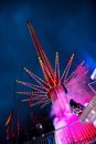 Molln, Germany, November 06, 2021: Fast ride spinning around a high tower with red lights and pink fog on an annual traveling fun Royalty Free Stock Photo