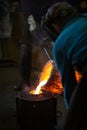Molten bronze poured into mold by melter in foundry workshop