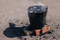 Molten hot tar in a bucket on the bricks. Roof repair