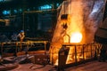 Molten iron pouring from blast furnace into ladle container, steel foundry factory, heavy metallurgy industry