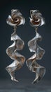 Molten metal style earrings, silver color and flowing shape.