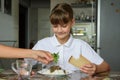 Mom adds fresh herbs to her daughter`s plate, daughter dines