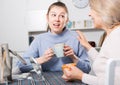 Mom and adult daughter talk and drink tea in the kitchen