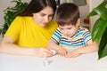 Mom applies bitter nail polish to the boy's nails to wead him from the bad habit of biting his nails