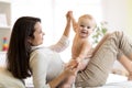 Mom and baby boy in diaper playing in sunny room. Mother and little kid relaxing at home. Family having fun together. Royalty Free Stock Photo