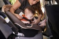 Mom, baby and car seat in motor vehicle for child safety with buckle or strap. Mother, infant and protection, travel and Royalty Free Stock Photo