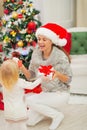 Mom and baby girl changing Christmas presents Royalty Free Stock Photo