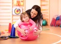 Mom and baby having fun with fitness ball in gym Royalty Free Stock Photo