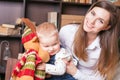 Mom with baby holding toy of big elk! Royalty Free Stock Photo