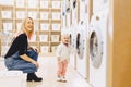 Mom and baby in the laundry take things and play Royalty Free Stock Photo