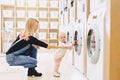 Mom and baby in the laundry take things and play Royalty Free Stock Photo