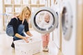 Mom and baby in the laundry take things and play Royalty Free Stock Photo