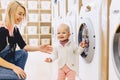 Mom and baby in the laundry take things and play Royalty Free Stock Photo