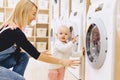 Mom and baby in the laundry take things and play Royalty Free Stock Photo