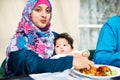 Mom, baby and muslim in table for dinner with food for eid, ramadan and religion to enjoy at home. Faith, Islam and Royalty Free Stock Photo