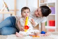 Mom and baby playing musical toys at home Royalty Free Stock Photo