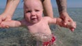 Mom with a baby in the sea water. Child body tempering. Train kids.