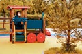 Mom baby sitting in a toy train in the playground Royalty Free Stock Photo
