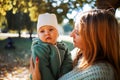 Mom and baby together. Young mother hugging and kissing her little son in autumn park. Happy family Royalty Free Stock Photo