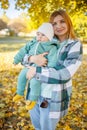 Mom and baby together. Young mother hugging and kissing her little son in autumn park. Happy family Royalty Free Stock Photo