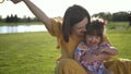 Mom and beautiful daughter laughing on meadow